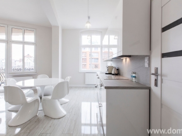 Białe, surowe ściany, pełne blasku meble i dodatki - nowoczesny apartament w stylu glamour