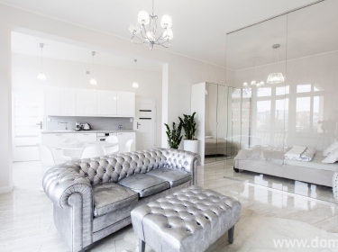 Białe, surowe ściany, pełne blasku meble i dodatki - nowoczesny apartament w stylu glamour