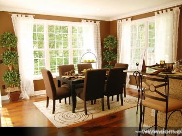 Przestronny, klasycznie urządzony salon z jasną jadalnią i przejściem do kuchni, w domu piętrowym dla kilkuosobowej rodziny.